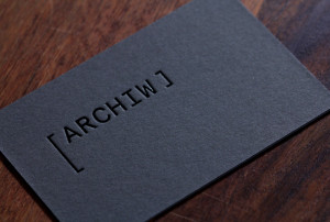 Archiw studio - přední strana, černá ražba na tmavě šedém papíru